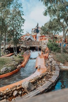 an amusement park with a waterfall and bridge