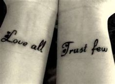 two wrist tattoos with the words love all trust few