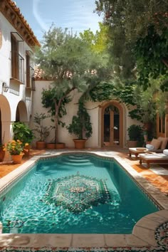 an outdoor swimming pool surrounded by greenery and potted plants in front of a house