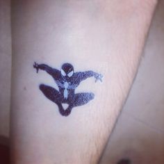 a person with a spider man tattoo on their left arm and the image is drawn in black ink