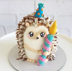 a hedgehog figurine holding a candy cane