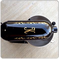 a black and gold wine bottle on a wooden table with the number 25 engraved on it