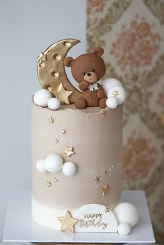 a teddy bear is sitting on top of a cake with stars and moon decorations around it