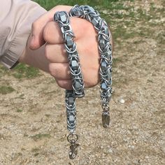 a person holding some kind of chain in their hand and wearing it as a bracelet