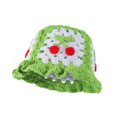 a green and white crocheted hat with red eyes