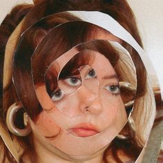 a woman with glasses on her face and some scissors in front of her head that is cut out to look like a circle