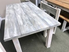 a wooden table sitting next to two chairs in a room with other furniture on the floor