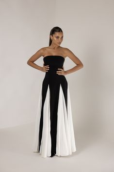 Introducing the Black Strapless Colorblock Pleated Maxi Dress, a refined combination of timeless sophistication and modern elegance. This striking piece features a sleek, strapless black bodice that accentuates the neckline and provides a flattering, fitted silhouette. Flowing into a stunning full-length skirt, the dress showcases dramatic pleated white inserts, creating a bold colorblock effect with graceful movement. The maxi length adds an air of sophistication, perfect for formal occasions, while the pleats bring a touch of contemporary style. Effortlessly blending classic charm with modern design, this dress ensures you make a lasting impression at any event. Heiress Beverly Hills, Corset Pants, Graceful Movement, Full Length Skirts, Pleated Maxi Dress, Pleated Maxi, Clothes Ideas, Fitted Silhouette, Blazer Dress