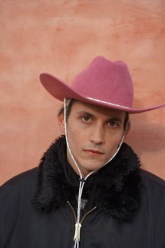 Meet Candy Vision pink cowboy hat—our reimagined cowboy hat that combines classic Western style with modern edge. This unique hat features a crisp center crease and a flanged brim, embodying timeless elegance with a hint of rugged charm. A reflective Paracord chin strap adds a contemporary twist, and playful charm. Each hat is handcrafted in our Stockholm studio, ensuring exceptional quality and a perfect fit for all. Pink Cowboy Hat, Pink Cowboy, Felt Cowboy Hats, Unique Hats, Pink Fur, Hat Style, Cowboy Style, Cowboy Hat, Western Style