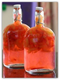 two bottles filled with liquid sitting on top of a table