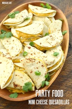 mini cheese quesadillas on a wooden platter with parsley in the middle