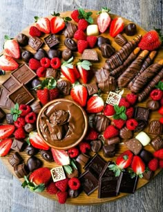 a platter filled with assorted chocolates, strawberries, and other treats