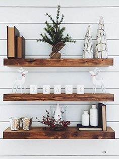 two wooden shelves with christmas decorations and candles on them, along with other holiday decor