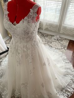 a white wedding dress on display in front of a window