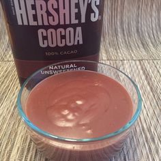 a jar of hershey's cocoa sits next to a glass bowl filled with chocolate