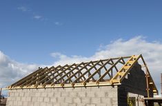 a house being built with wooden framing and roof trusses on the top of it