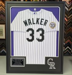 a framed baseball jersey with the number 33 on it is in front of some other memorabilia