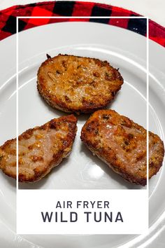 three pieces of meat on a plate with the words air fryer wild tuna over it