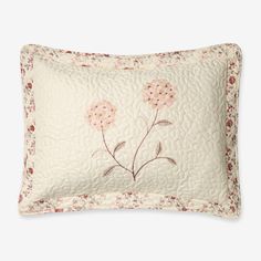 a white pillow with pink flowers on it