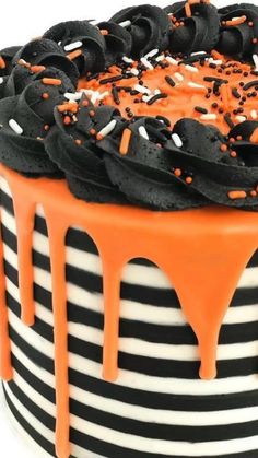 a black and white striped cake with orange sprinkles on the icing