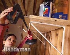 a woman is holding an object up to the ceiling in front of a shelf with other items on it