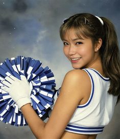 a young woman holding a blue and white cheerleader's pom - pom