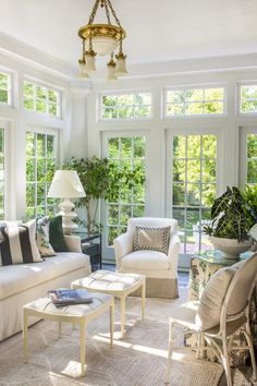 a living room filled with white furniture and lots of windows on top of each other