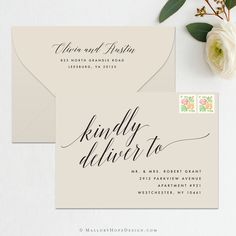 wedding stationery with envelope and save the date stamp on it, next to flowers