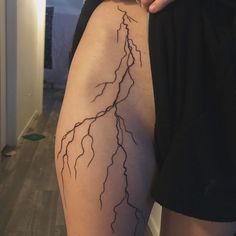 a woman's thigh with lightning tattoo on it