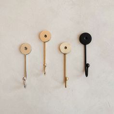 three different types of handles and hooks on a white surface with one black, the other gold