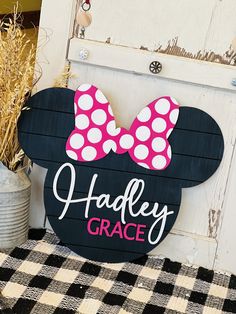 a minnie mouse sign with a pink bow on it's head and the words handley grace