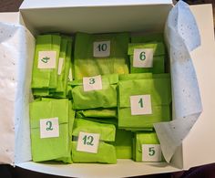 a box filled with lots of green bags and numbered numbers on the inside of it