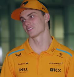 a young man in a yellow shirt and cap looking at the camera with an intense look on his face