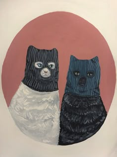 two cats wearing sweaters in front of a red circle