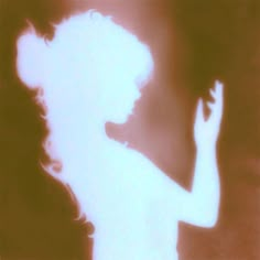 the silhouette of a woman is shown with her hand up in front of her face