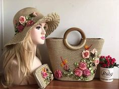 a mannequin wearing a hat with flowers on it next to a basket and purse