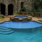 an outdoor swimming pool surrounded by stone walls