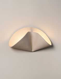 a light that is on the side of a white wall with a triangle shaped surface