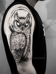 an owl tattoo on the left arm and shoulder is shown in black and grey colors