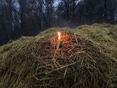 a lit candle sitting on top of a pile of hay