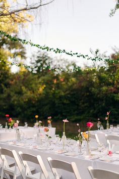 the tables are set with white linens and flowers