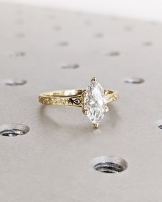 a close up of a ring with a diamond in it on a surface that has dots