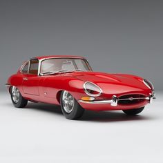 an old model red sports car on a white background