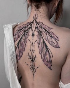 the back of a woman's neck with tattoos on it