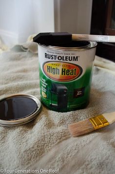 a paint can and brush sitting on top of a bed