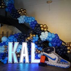 balloons are arranged around the letters that spell out kal in front of a staircase