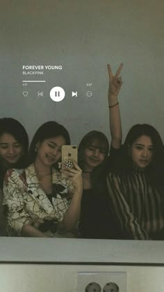 a group of women standing next to each other in front of a tv screen with the words forever young on it