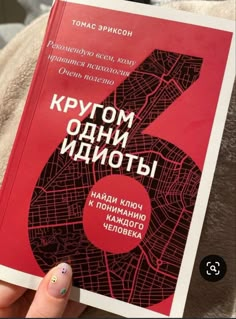 a person holding up a book with the number six in russian on it's cover