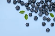 blueberries and leaves on a light blue background