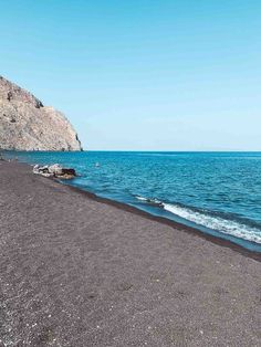 the beach is empty and blue with waves coming in